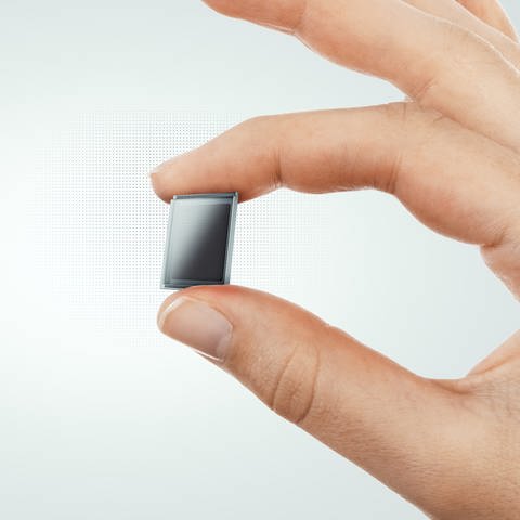 Eine Solarzelle gehoben von 2 Fingern (Foto: Ambient Photonics)