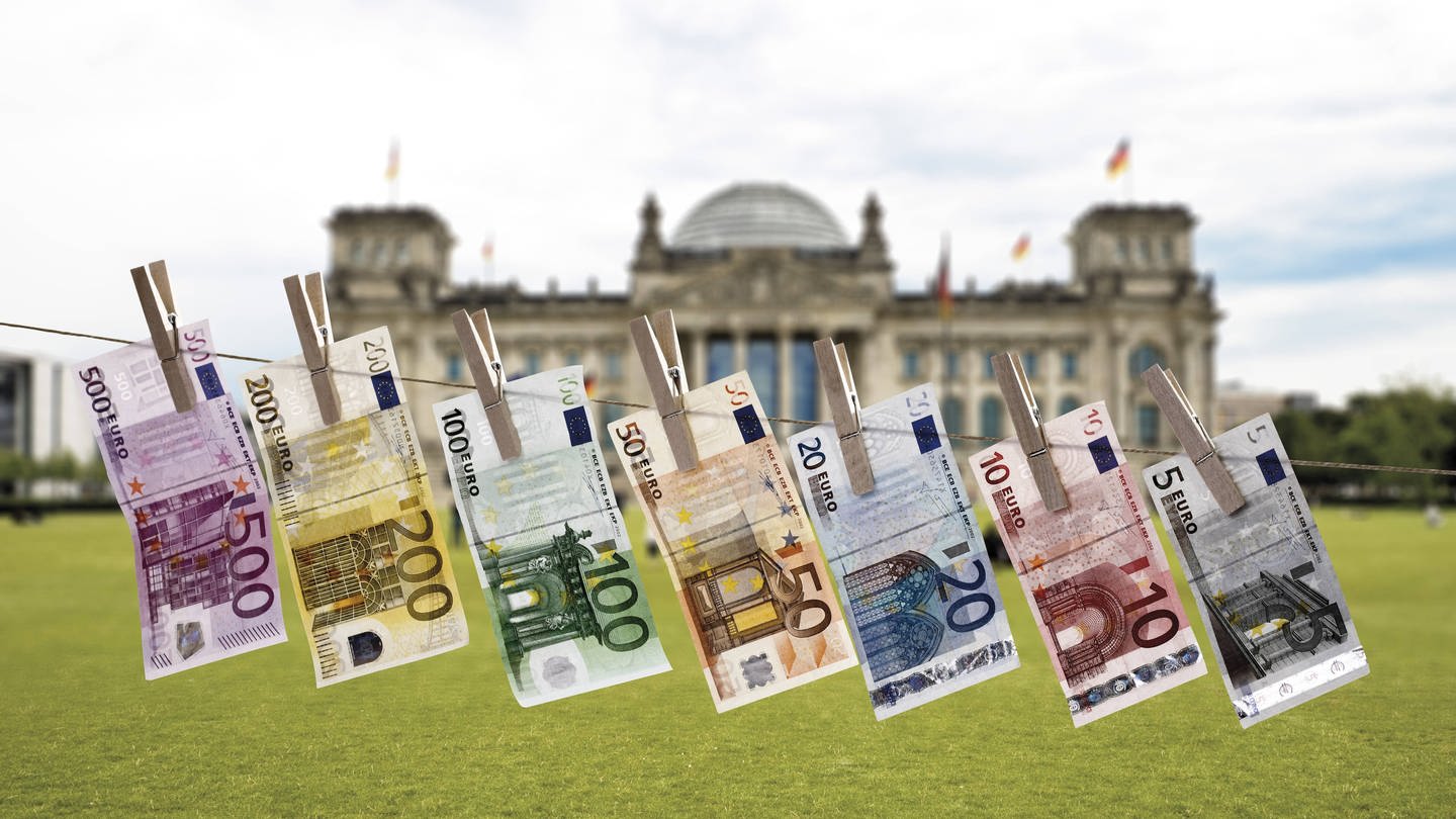 Geldscheine auf einer Wäscheleine vor dem Reichstagsgebäude in Berlin: Deutschland macht es Geldwäschern aus dem In- und Ausland zu leicht (Foto: IMAGO, imago images / Westend61)