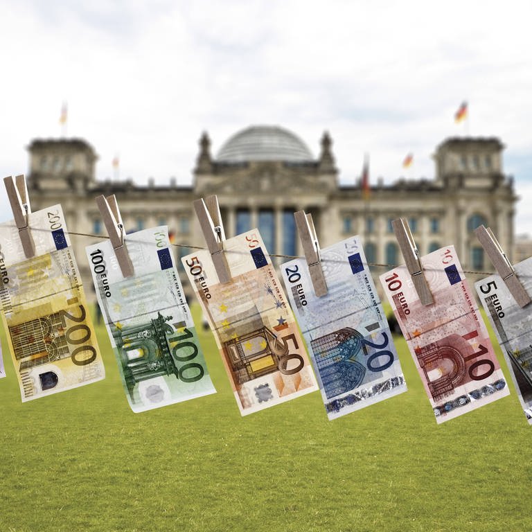 Geldscheine auf einer Wäscheleine vor dem Reichstagsgebäude in Berlin: Deutschland macht es Geldwäschern aus dem In- und Ausland zu leicht (Foto: IMAGO, imago images / Westend61)