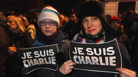 Zwei Frauen tragen Schilder mit der Aufschrift "Je suis Charlie". 