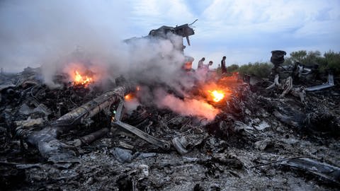 Brennende Trümmer einer Boeing 777 der Malaysia Airlines liegen nahe Donezk in der östlichen Ukraine. Das Passagierflugzeug mit der Flugnummer MH17 war am 17. Juli 2014 mit 283 Passagieren und 15 Crewmitgliedern an Bord abgeschossen worden. (Foto: dpa Bildfunk, picture alliance/dpa/epa | Alyona Zykina)