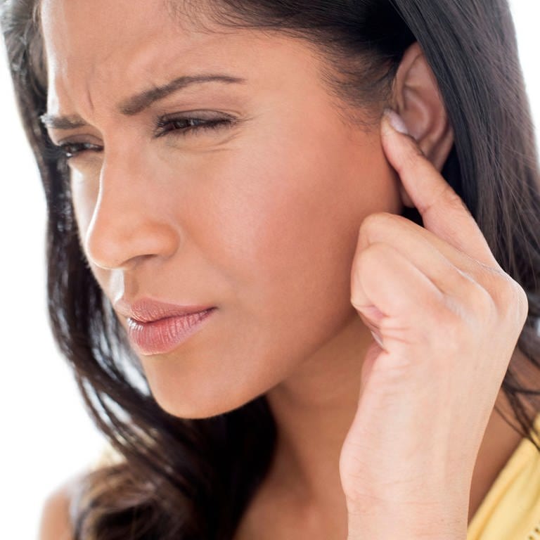 Junge Frau mit Ohrproblemen verzieht das Gesicht: Einen Tinnitus bekommt man nicht weg, aber man kann über eine kognitive Verhaltenstherapie erreichen, dass man mit dem Tinnitus besser klarkommt. 
