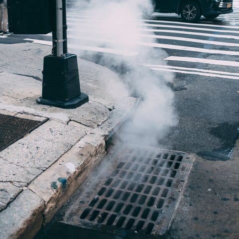 New York: Dampf weicht aus einem Gullideckel heraus (Foto: IMAGO, IMAGO / Mika Volkmann)