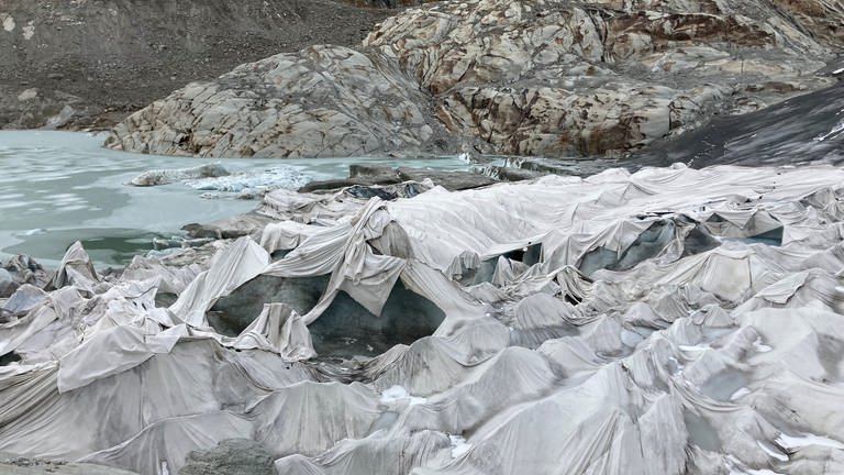 Dass die Grotte am Rhonegletscher überhaupt noch existiert, liegt an großen Textilplanen, mit denen das untere Ende des Gletschers bedeckt wurde (August 2022) (Foto: SWR, Kathrin Hondl / ARD Studio Genf)