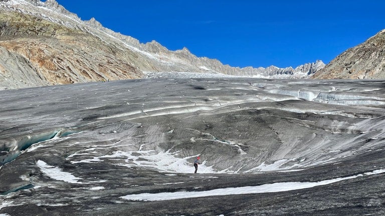 Auf der Gletscheroberfläche ist eine Art Trichter entstanden, der aus der Ferne aussieht wie ein großer Kreis im schmutzig grauen Eis. Glaziologe Andreas Bauder: "Wir vermuten, dass sich unter dem Gletscher, also an der Basis, eine Höhle gebildet hat, und die Eisdecke jetzt sehr gering geworden ist und deshalb einsinkt.“ (Oktober 2022) (Foto: SWR, Kathrin Hondl / ARD Studio Genf)