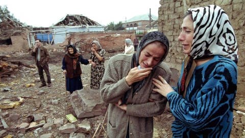 Tschetschenische Frauen weinen am 2. Oktober 1999 in den Ruinen ihrer Häuser, die durch russische Luftangriffe zerstört worden sind. Russische Truppen haben seit dem Einmarsch in Tschetschenien etwa ein Drittel des Territoriums der abtrünnigen Kaukasusrepublik unter Kontrolle gebracht. Dies gab der damalige russische Ministerpräsident Putin bekannt. Die Einheiten hätten etwa 30 Ortschaften erobert. (Foto: picture-alliance / Reportdienste, picture-alliance / dpa | epa)