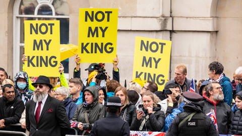 Demonstranten halten am Tag der der Krönung von König Charles III. und Queen Camilla in London am 6. Mai 2023 in Whitehall antimonarchistische Schilder hoch: "NOT MY KING" ist darauf zu lesen (Foto: picture-alliance / Reportdienste, picture alliance / ASSOCIATED PRESS | Antonio Olmos)