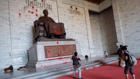Taiwanische Aktivisten werfen am 20. Juli 2018 rote Farbballons auf die Statue Chiang Kai-sheks. Sie zeigen damit Solidarität mit Unterstützern der taiwanischen Unabhängigkeitsbewegung, die den Sarg des ehemaligen Diktators zum 71. Jahrestag des 228-Massakers mit roter Farbe beschmiert hatten und deren Gerichtsprozess am 20. Juli 2018 startete. (Foto: IMAGO, IMAGO / AFLO)