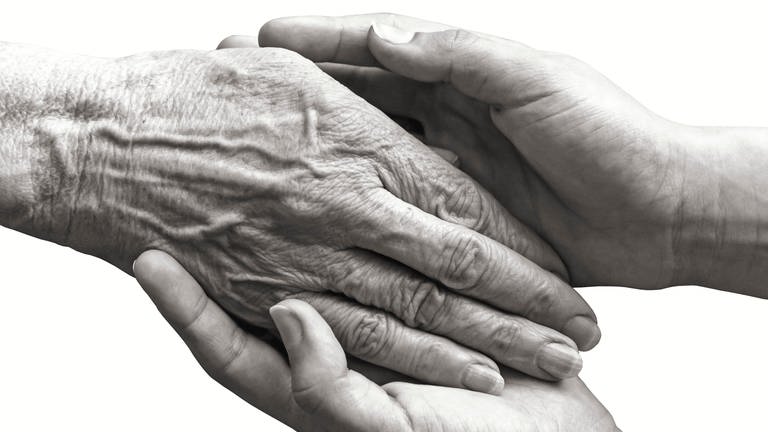 Junge Hände halten eine ältere Hand