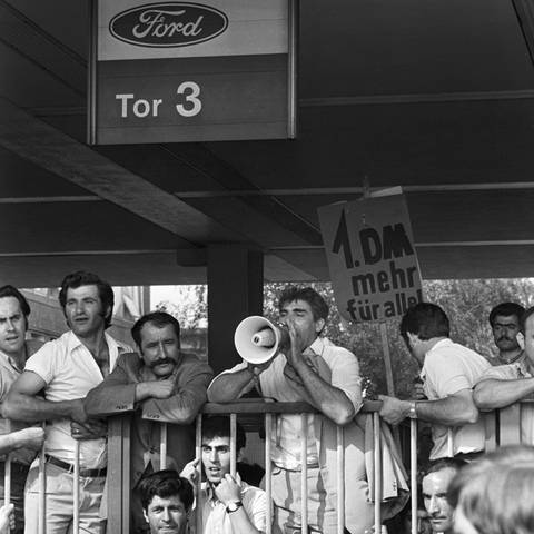 Eine Gruppe überwiegend türkischer Arbeiter des Automobilherstellers Ford befindet sich im August 1973 im wilden Streik im Kölner Werk und verkündet an Tor 3 über ein Megaphon ihre Forderungen. Der erste Arbeitskampf in Deutschland, der hauptsächlich von Gastarbeitern getragen wurde, ging mit einer Betriebsbesetzung einher.