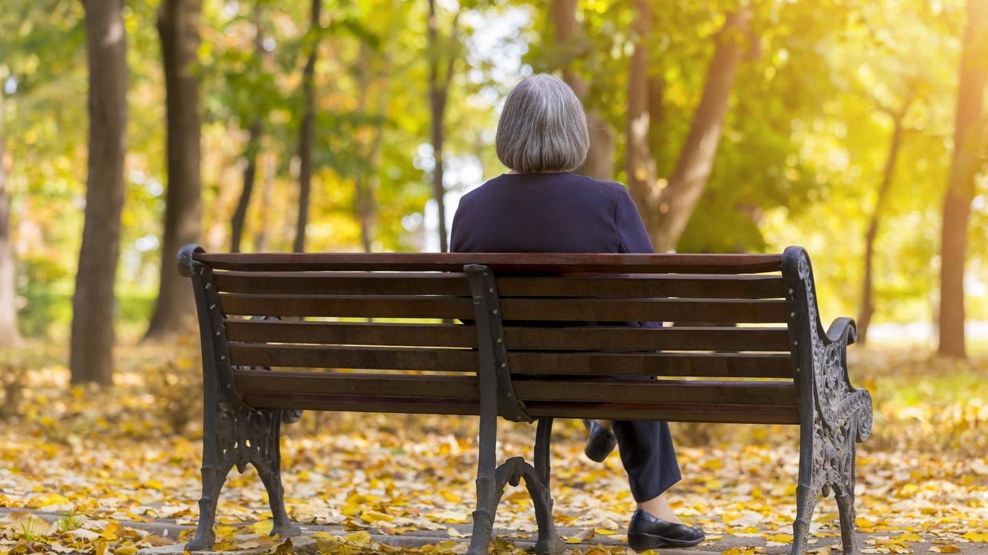 Ältere Frau sitz in einem Herbstwald einsam auf einer Bank: Einsamkeit ist ein wachsendes gesellschaftliches Problem. Unterschiedliche Projekte sollen einsamen Menschen helfen (Foto: IMAGO, IMAGO / Panthermedia)