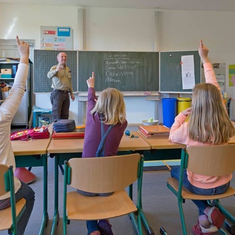 Schüler in der Grundschule melden sich im Unterricht (Foto: IMAGO, IMAGO / imagebroker)