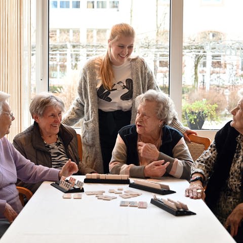 Bewohnerinnen einer Seniorenresidenz bei einem Gesellschaftsspiel