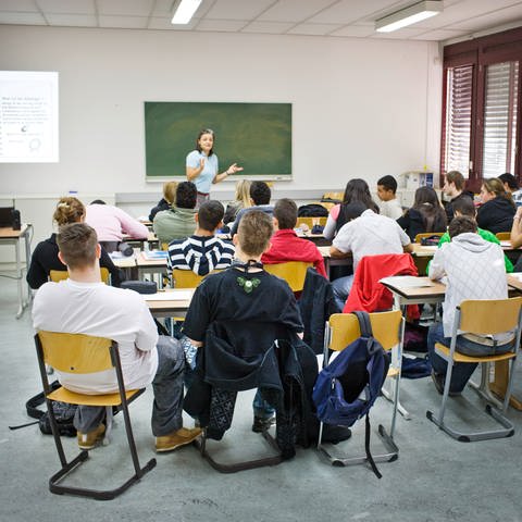 Lehrerin steht vor einer Klasse der Oberstufe. (Foto: picture-alliance / Reportdienste, picture alliance / photothek | Thomas Trutschel)
