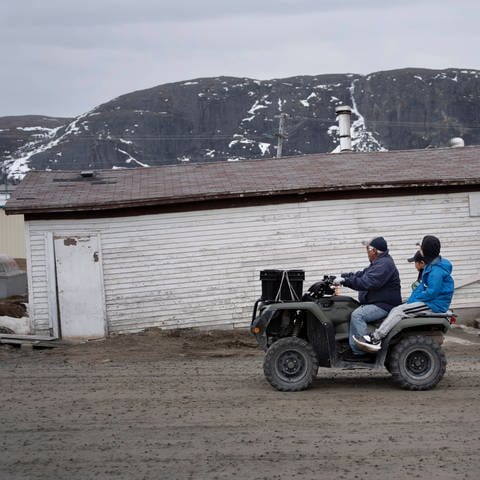 Kanada: Einheimische fahren an einem durch Erwärmung des Permafrostes, geneigten, schiefen Gebäude vorbei.  (Foto: IMAGO, IMAGO / ZUMA Press)