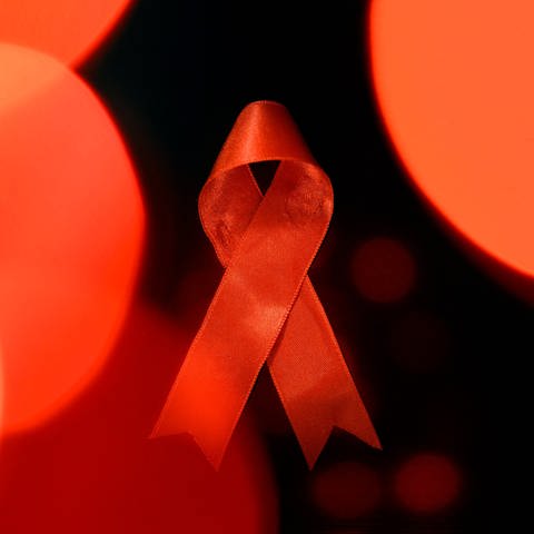 Symbolbild: rote Schleife für den Welt-AIDS-Tag. (Foto: IMAGO, IMAGO / Panama Pictures)
