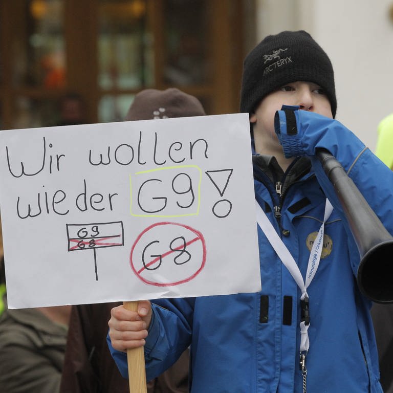 Demonstration für das neunjährige Gymnasium. Ein Junge mit einer Tafel in der Hand und der Aufschrift "Wir wollen wieder G9".  (Foto: picture-alliance / Reportdienste, picture alliance / dpa | Markus Scholz)