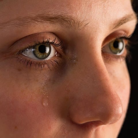 Gesicht einer unglücklichen Frau in Tränen aus der Nähe in der Dunkelheit. (Foto: picture-alliance / Reportdienste, picture alliance / Zoonar | Jakub Mrocek)