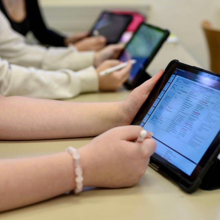 Schüler und Schülerinnen an iPads im Unterricht