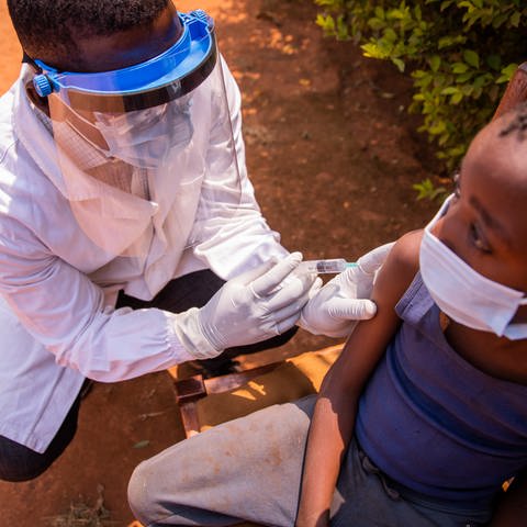 Ein Arzt impft ein Kind in Afrika 