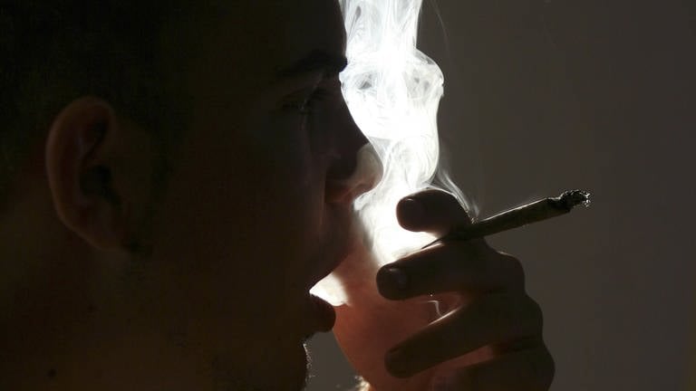 Ein Jugendlicher, der einen Joint raucht (Foto: picture-alliance / Reportdienste, picture-alliance / BSIP/LEMOINE | LEMOINE)