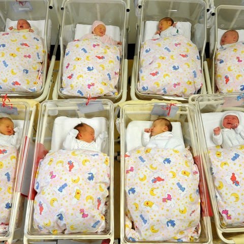 Viele Babys liegen zusammen auf einer Neugeborenenstation