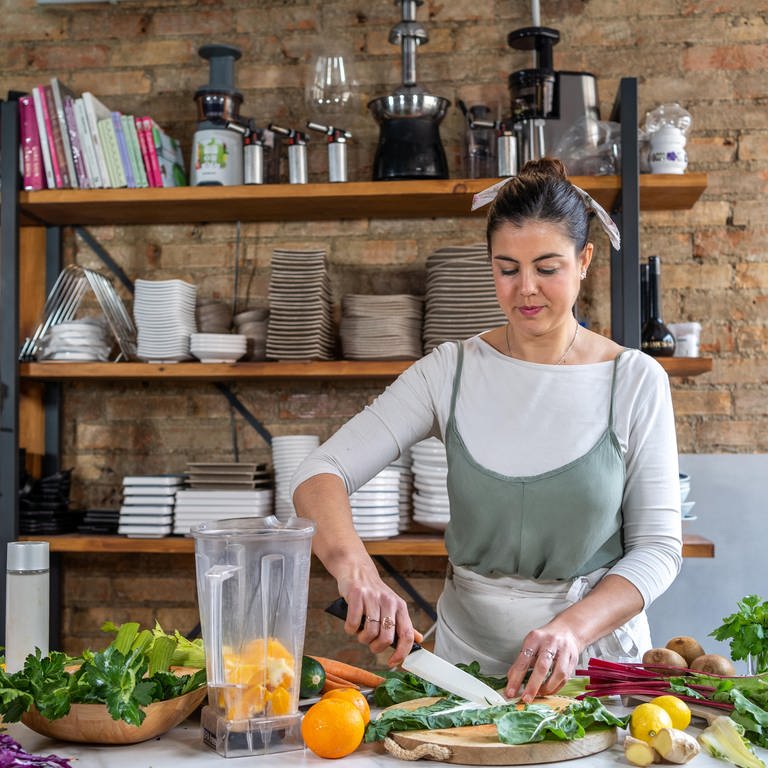 Eine Frau verarbeitet Obst und Gemüse in der Küche