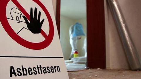 Warnschild Asbest vor sanierungsbedürftigem Raum