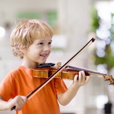 Ein Junge übt Geige: Es reicht nicht, 10.000 Stunden zu üben, um meisterlich in einem Fach zu werden. Aber: Talent allein reicht auch nicht. Motivation, Disziplin und ein förderndes Umfeld sind zudem wichtig. Was genau ist Talent? 