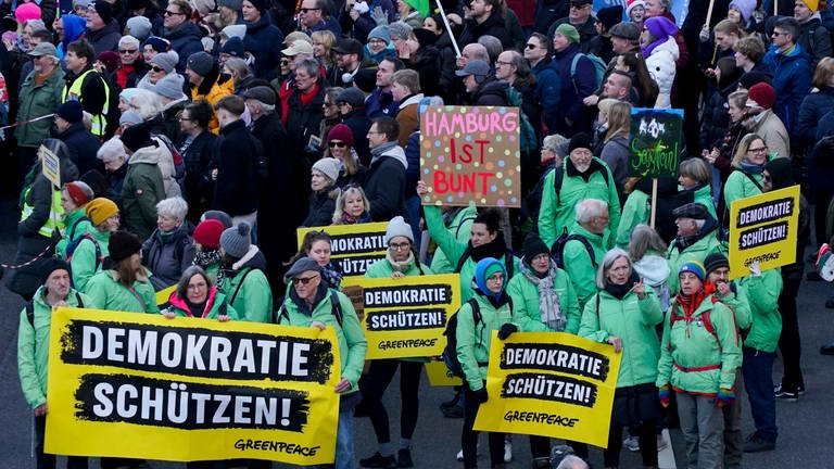 Gut 60.000 Menschen demonstrieren am 28 Januar 2024 in Hamburg friedlich mit Fahnen, Bannern und Protestschildern gegen die AfD. Auf Greenpeace-Transparenten steht "Demokratie schützen!"
