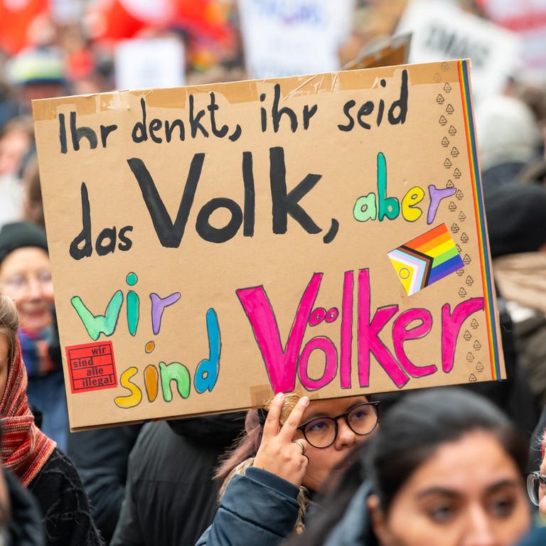 "Ihr denkt, ihr seid das Volk, aber wir sind Völker" steht im Februar 2024 auf einem Schild bei einer Demonstration gegen Rechtsextremismus und die AfD in der Innenstadt von Lübeck. – Wen schließt der Begriff Volk ein und wen aus? Ist die Bezeichnung überhaupt noch zeitgemäß?