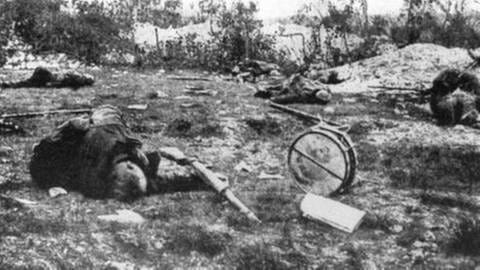 Tote liegen auf einem Schlachtfeld, Verdun 1916, neben den Toten Waffen, eine Trommel
