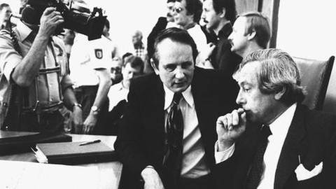 Der Schriftsteller Rolf Hochhuth (l) sitzt mit seinem Anwalt Heinrich Senfft (r) im Landgericht in Stuttgart vor der Urteilsverkündung am 13.7.1978