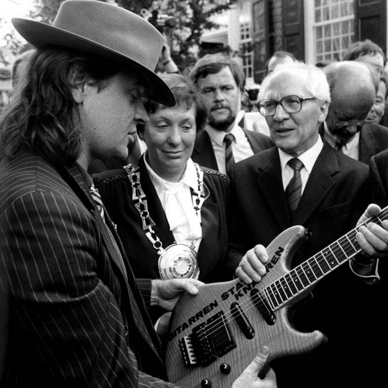 Rockmusiker Udo Lindenberg (links) überreicht SED-Generalsekretär Erich Honcker bei dessen Besuch in Wuppertal am 9. September 1987 eine Gitarre mit der Aufschrift "Gitarren statt Knarren"