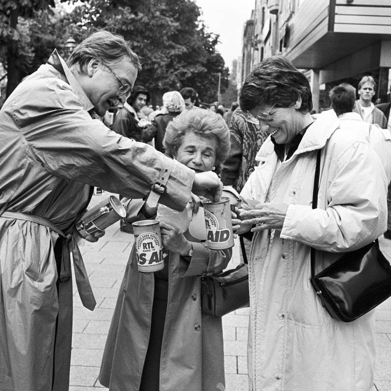 Bundesgesundheitsministerin Rita Süssmuth (rechts) und und die amerikanische Sexualtherapeutin Ruth Westheimer (Mitte) sammeln am 29. Mai 1987 auf der Königsallee in Düsseldorf Spenden für an Aids erkrankte Kinder in der Bundesrepublik. Die Spendenaktion "Aids-Kids" soll einen bessere Betreuung und Versorgung der rund 400 Aids-kranken Kinder in Deutschland gewährleisten.