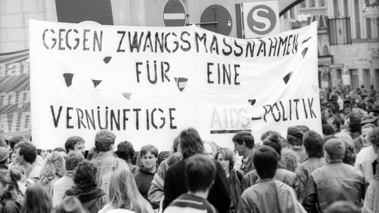"Gegen Zwangsmaßnahmen, für eine vernünftige Aids-Politik": Plakat auf der Aids-Demonstration am 4. April 1987 auf dem Marienplatz in München gegen die Diskriminierung Homosexueller 