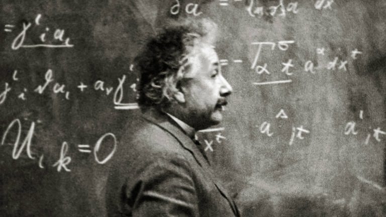 Albert Einstein um 1925. Der Physiker steht vor einer Tafel mit vielen Formeln (Foto: IMAGO, IMAGO / Cinema Publishers Collection)