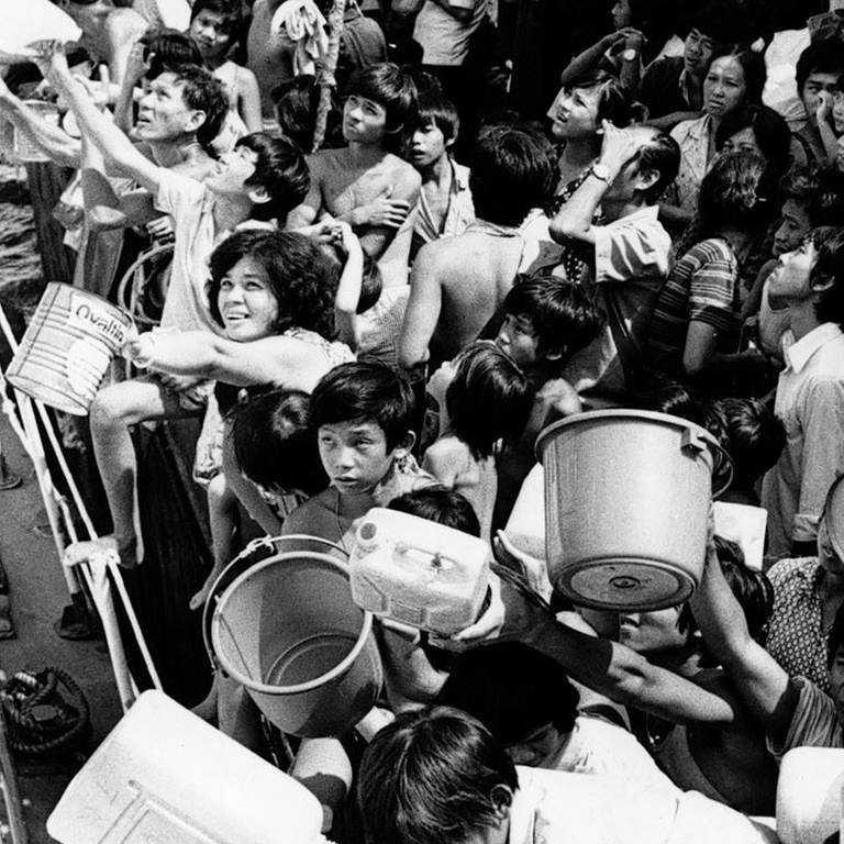 Vietnamesische "Boat People" an Bord des Flüchtlingsschiffs "Tung An" halten den Besatzungsmitgliedern eines Schiffes der philippinischen Marine, das am 21. Februar 1979 mit frischem Trinkwasser anlegte, Eimer und Kanister hin. Seit acht Wochen sitzen die Flüchtlinge an Bord der Tung An in der Bucht von Manila fest.