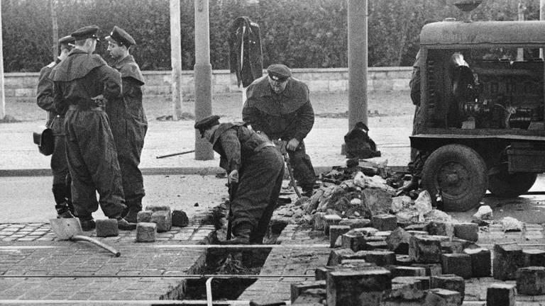 13. August 1961: Angehörige des ostdeutschen Militärs entfernen Pflastersteine ​​in der Friedrichstraße in Ost-Berlin