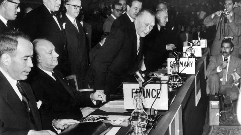 Bundeskanzler Konrad Adenauer (Mitte) nimmt seinen Platz im Atlantikrat ein: Auf der Sitzung im atlantischen Hauptquartier Palais de Chaillot bei Paris wurde die Bundesrepublik Deutschland in die NATO aufgenommen (Foto: dpa Bildfunk, picture alliance/dpa)