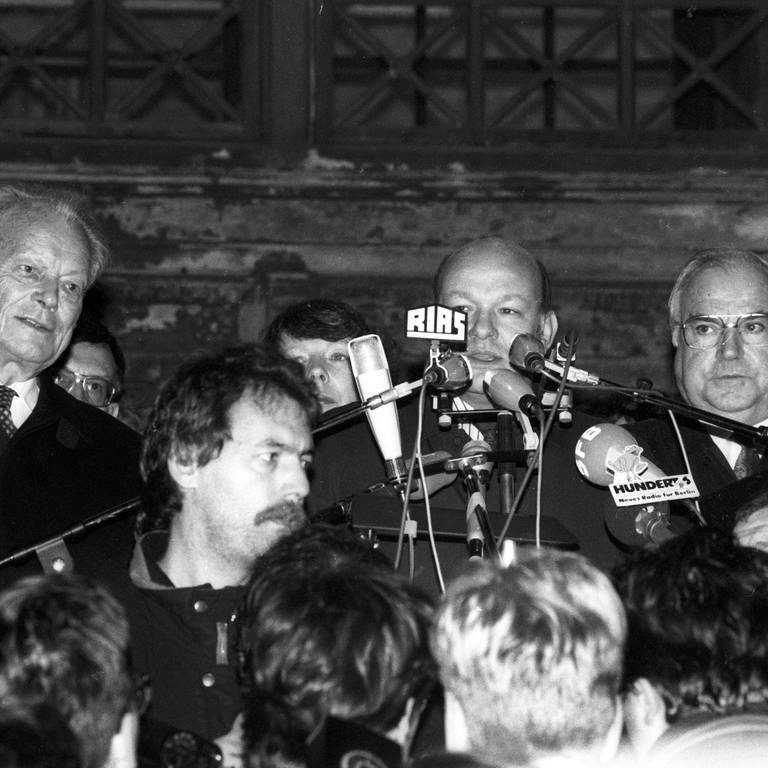 Walter Momper (Mitte, SPD, Regierender Bürgermeister Berlin) neben Bundeskanzler Helmut Kohl (2.v.re., CDU) und Willy Brandt (li., SPD) während einer Kundgebung vor dem Schöneberger Rathaus in Berlin am 10.11.1989 (Foto: IMAGO, imago/Dieter Bauer)