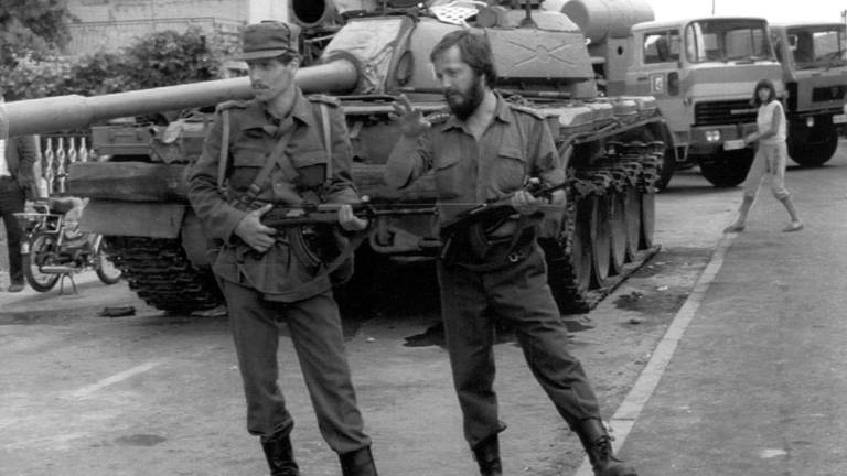 Zwei slowenische Soldaten stehen am 29. Juni 1991 in Maribor vor einem von zwei erbeuteten jugoslawischen Panzern.