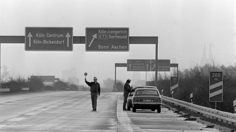 Polizisten kontrollieren am 25. November 1973 am Autobahnkreuz Köln-Nord die Einhaltung des Fahrverbots. Nur Verkehrsteilnehmer mit Sondergenehmigungen durften an diesen Tag ihr Fahrzeuge benutzen. Wegen der anhaltenden Ölkrise wurde am 25.11.1973 zum ersten Mal ein sonntägliches Fahrverbot verhängt.