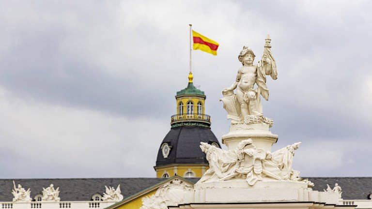 Die badische Flagge in gelb-rot-gelb weht auf dem Karlsruher Schloss: Der Heimatbund Badenerland erreichte 1970 eine neue Volksabstimmung im badischen Teil Baden-Württembergs.  (Foto: IMAGO, IMAGO / Arnulf Hettrich)