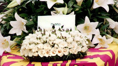 "Mummy" steht auf der Karte hinter dem Rosengebinde und vor den weißen Lilien auf dem in die Königsstandarte gehüllten Sarg Prinzessin Dianas – ein letzter Gruß von William und Harry an ihre Mutter bei der Trauerfeier in London am 6. September 1998  (Foto: picture-alliance / Reportdienste, picture-alliance / dpa | epa AFP Robine)