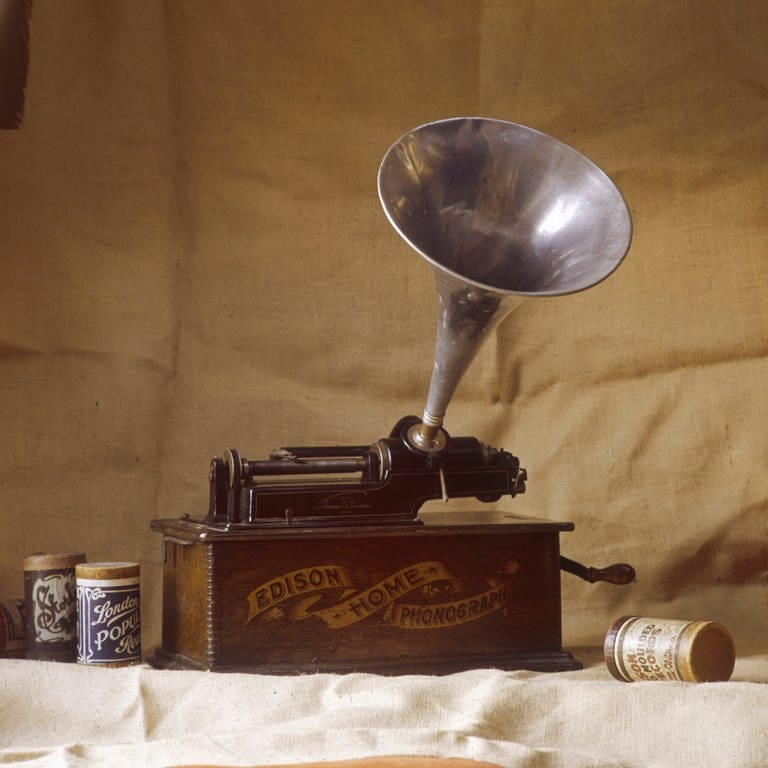 Ein früher Edison-Phonograph mit gerillten Wachszylindern neben dem Instrument; Anfang 20. Jahrhundert