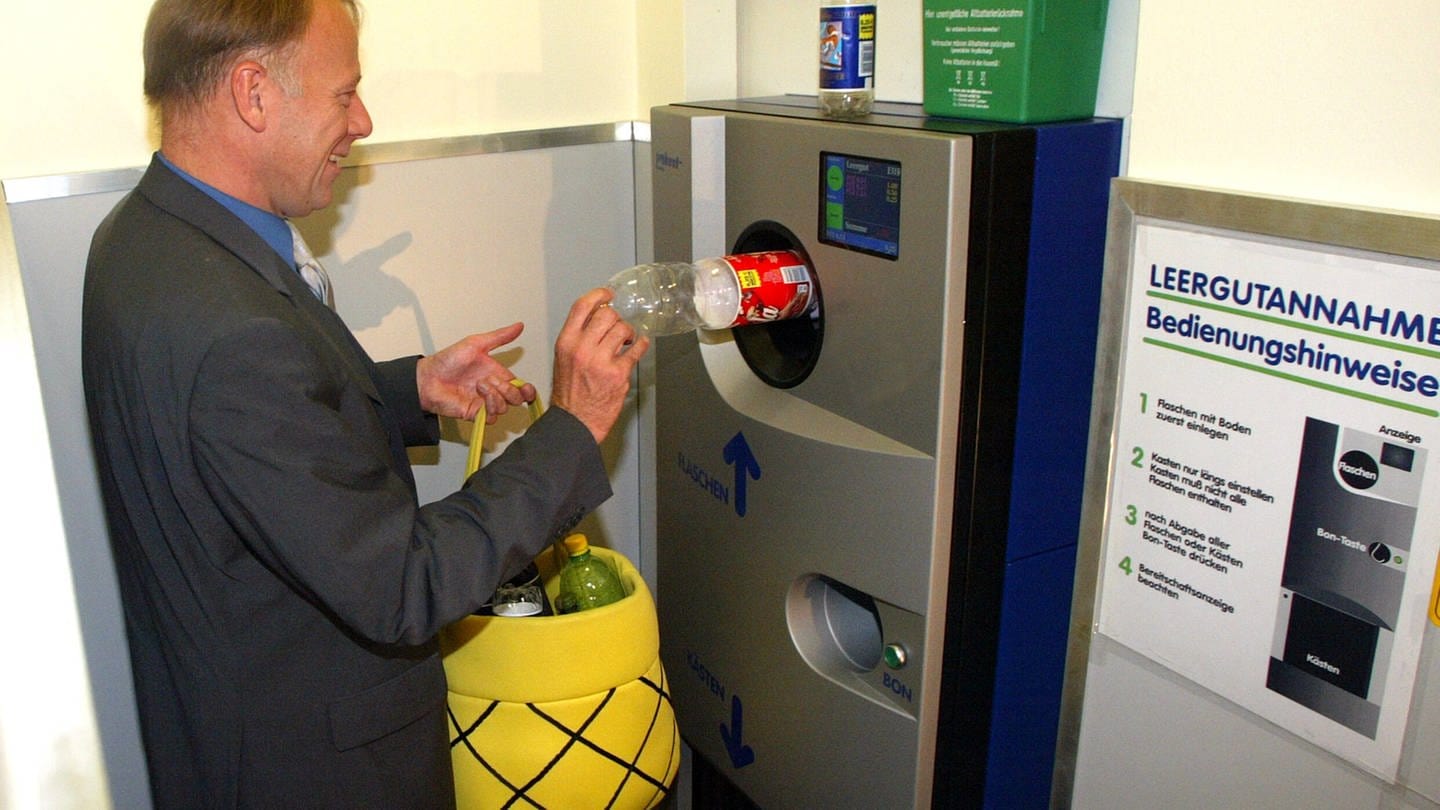 Bundesumweltminister Juergen Trittin steckt 2003 eine Flasche in einen Getränkeautomaten (Foto: IMAGO, IMAGO / Uta Wagner)