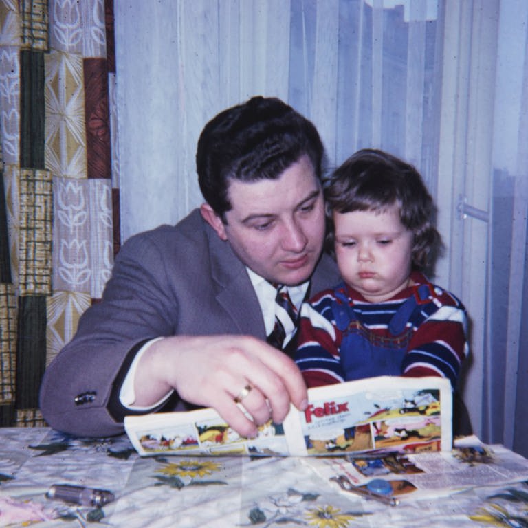 Vater liest 1956 Kind aus einem Comic vor: 1955 hatte der Bundesgerichtshof (BGH) geurteilt: Comics, loange als Schund verschrien, sind nicht per se jugendgefährdend (Foto: IMAGO, IMAGO / serienlicht)