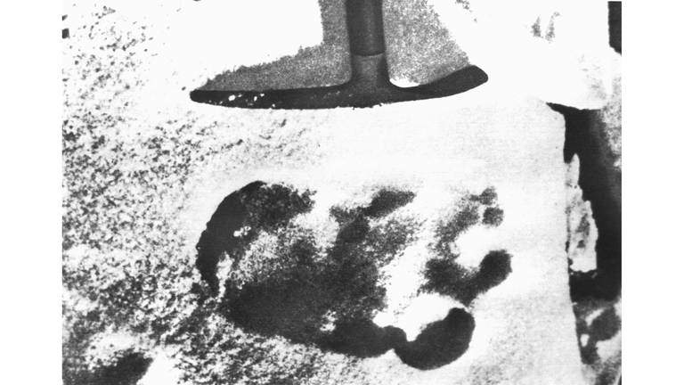 Das Archivbild von 1951 zeigt eine Spitzhacke, die auf einen großen unidentifizierten Fußabdruck im Schnee des Himalaya deutet. Eine Expedition stieß 1951 auf den Abdruck und schrieb ihn dem sagenumworbenen Schneemenschen Yeti zu. (Foto: picture-alliance / Reportdienste, dpa Bildfunk, picture alliance / dpa )