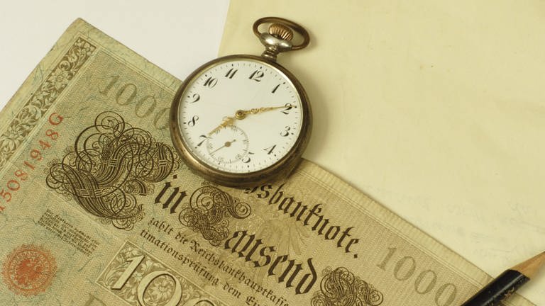 Taschenuhr auf einer alten 1000-Mark-Banknote (Foto: IMAGO, IMAGO / Panthermedia)